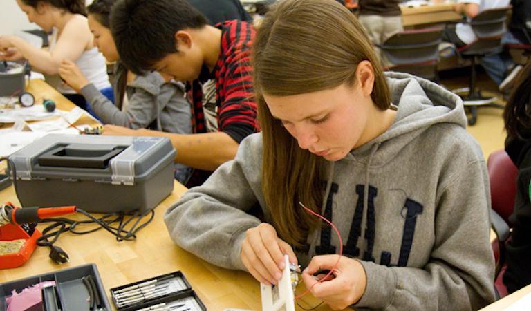 学生 works on electronic project at workbench